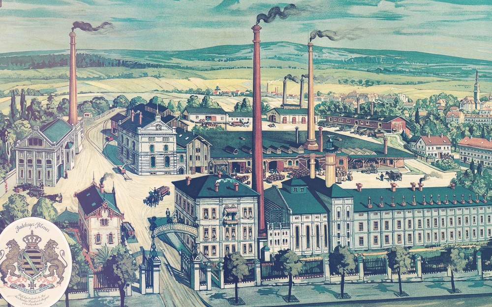 Old factory buildings stand on a fenced-in property. At the entrance gate, a sign reads Radeberger Exportbierbrauerei.