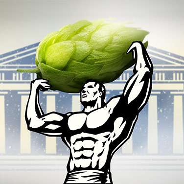A muscular man lifts a large hop cone above his head in front of a classic building.
