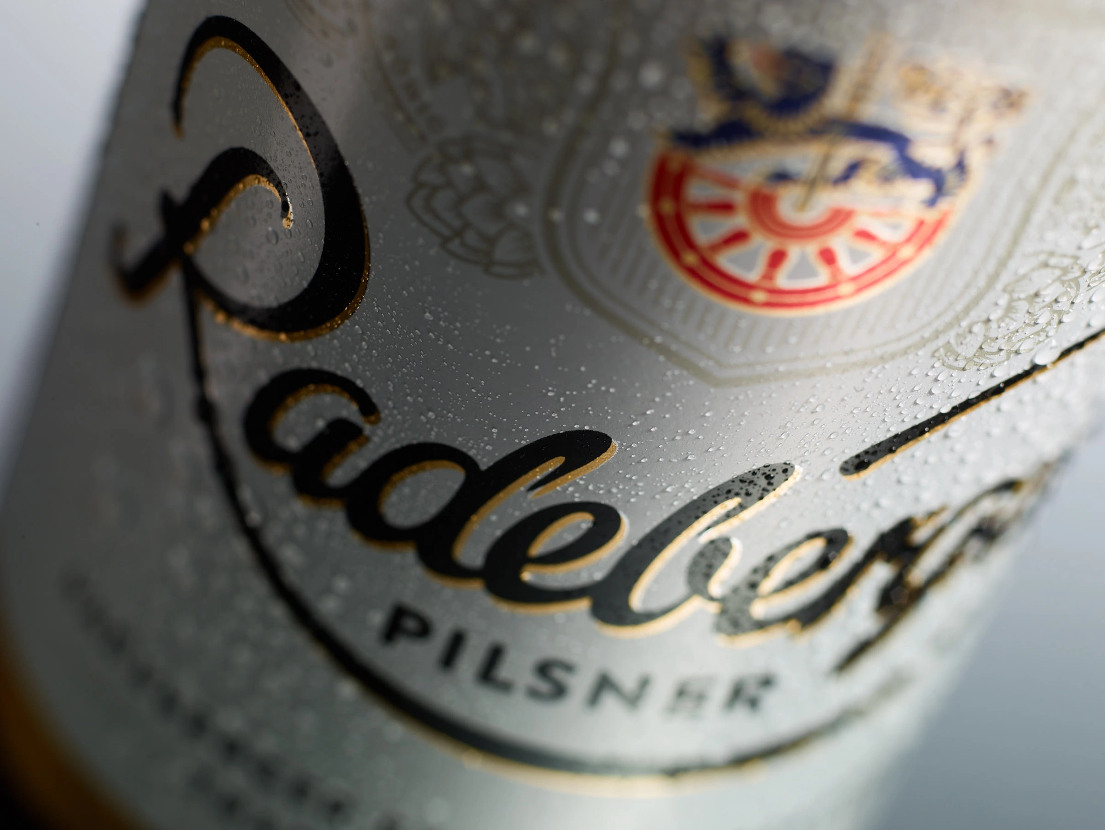 A close-up of a beer bottle label covered in condensation, bearing the words Radeberger Pilsner.