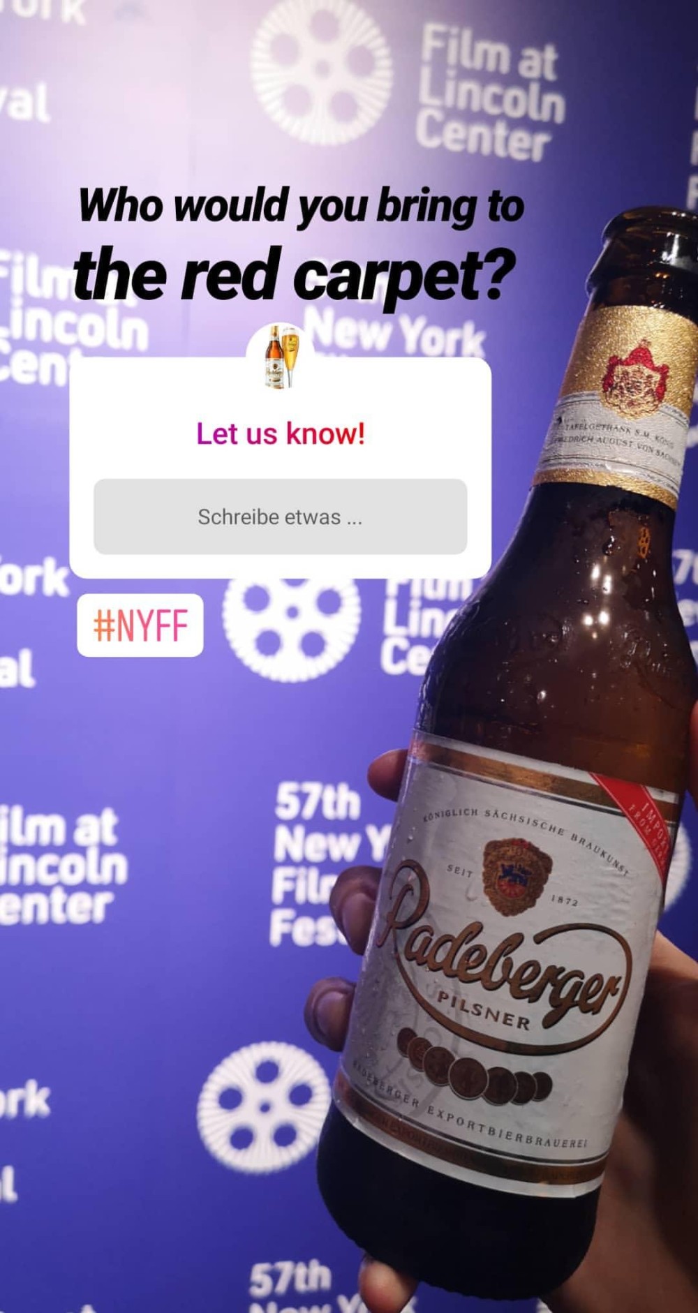 A hand holding a beer bottle in front of a blurred advertisement for a film festival.